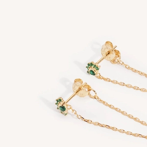 Golden sun flower earrings with green crystals and long tassel chains on white background