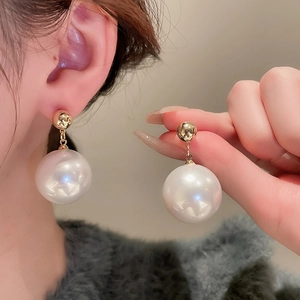 Vintage geometric pearl earrings with gold-plated pins worn by a model for a classy look