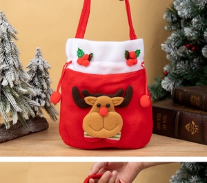 Détail d'un sac cadeau de Noël en peluche rouge avec renne 3D et bordure en fausse fourrure