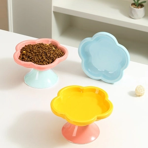 Detailed view of three pastel ceramic flower-shaped raised pet bowls for cats and dogs