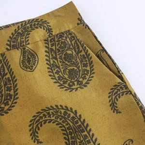Détail du haut et pantalon en satin jaune à motif paisley avec poches latérales