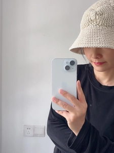 Selfie montrant la texture en maille d'un chapeau bob en coton fait main blanc cassé