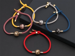 Close-up of colorful braided rope bracelets with gold-plated cubic zirconia charms