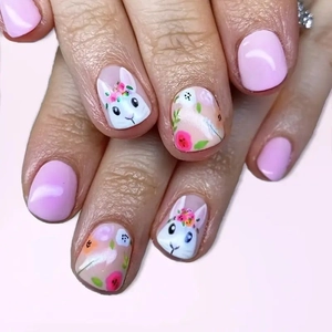 Close-up of Easter press-on nails featuring cute white rabbits and pink floral patterns
