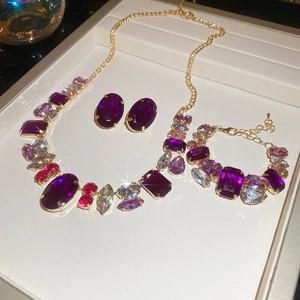 Detailed luxury jewelry set macro view with purple crystals and golden necklace
