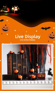 Detail of Halloween spider LED candle lamp with glowing orange flame on vintage books