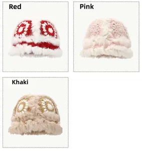 Close-up of plush winter beanies in red, pink, and khaki with thick faux fur trim and flowers