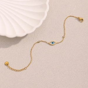 Detail of 18K gold-plated evil eye bracelet with blue enamel and zircon on beige background