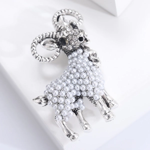 Detailed view of silver sheep brooch with pearl body and sparkling rhinestone accents