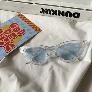 Chic cat eye sunglasses with transparent frames and light blue lenses on white fabric