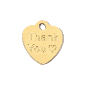 Macro shot of gold heart-shaped stainless steel pendant with Thank You engraving