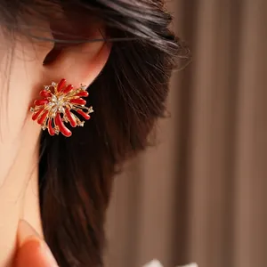 Elegant red enamel flower earrings with diamond accents and gold-plated finish