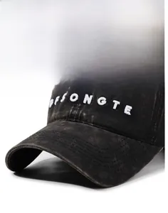 Detail of embroidered white letters on a vintage washed grey cotton baseball cap