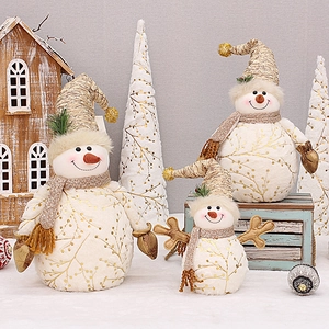 Three plush snowman figurines with gold branch patterns and knit scarves for Christmas decor