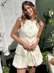 Détail du tissu en lin beige de l'ensemble deux pièces avec gilet et short de forme bulle