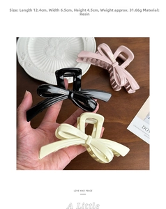 Detailed view of large resin bow hair claws with dimensions 12.4cm in black, pink and beige