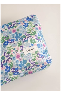 Primer plano de un neceser floral que muestra la textura de la tela y la etiqueta.