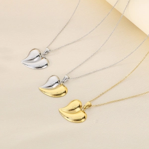 Detailed shot of three heart-shaped pendant necklaces in gold, silver, and two-tone finishes