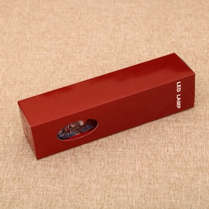 Detail view of deep red LED lamp gift packaging box with a clear oval viewing window