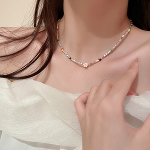 Gros plan détaillé d'un collier ras du cou en perles colorées avec pendentif marguerite