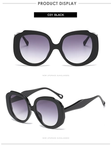 Close-up of oversized black round sunglasses with purple gradient lenses and glossy frames