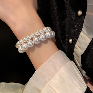 Close-up of double-layer white pearl bracelet worn on wrist with elegant French style