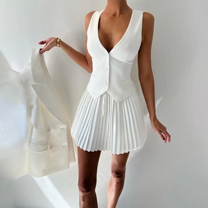Vue détaillée d'un ensemble gilet blanc sans manches et jupe plissée en tissu de qualité