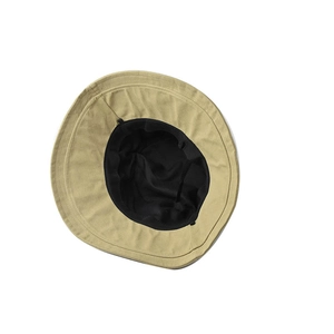 Detail view of cotton bucket hat featuring beige exterior, black lining and reinforced stitching