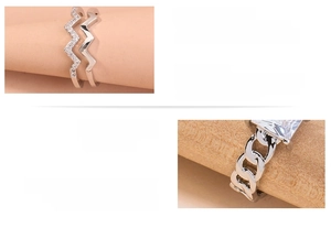 Detail of cubic zirconia rings with cuban chain link and pavé double-layer wave bands