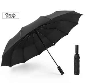 Detail of automatic classic black umbrella showing open canopy and compact folded state