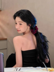 Pince à cheveux fleur en tissu bordeaux élégante sur cheveux noirs dans un cadre chic