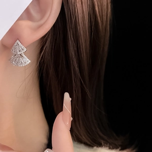 Macro shot of silver-plated double-layer fan earrings with cubic zirconia on model