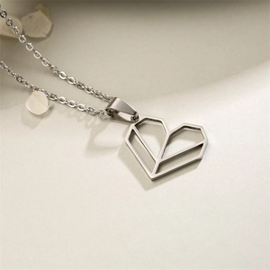 Silver hollow heart pendant necklace in stainless steel on a soft minimalist background