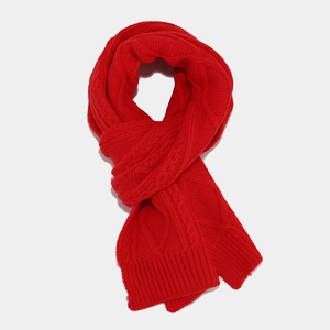 Close-up of red cable knit scarf featuring thick yarn texture and ribbed edge detailing