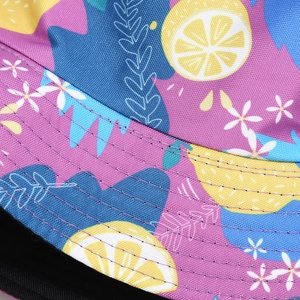 Detailed macro view of lemon pattern bucket hat with black stitching and canvas texture