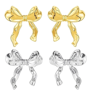 Minimalist brass bow stud earrings set in polished gold and silver metallic finishes