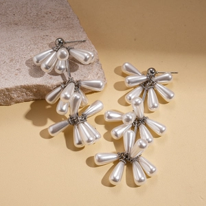 Macro view of baroque faux pearl waterdrop tassel earrings with silver finish metal