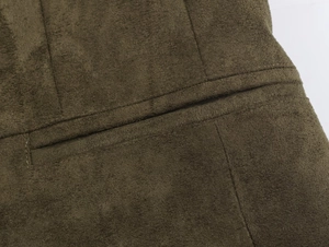 Detailed close-up of dark green suede blazer featuring a refined welt pocket and neat stitching