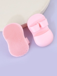 Detail of pink silicone facial cleansing brush with soft bristles and finger ring handle