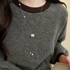 Long collier de perles élégant avec pendentif flocon de neige argenté et pompons en zircon