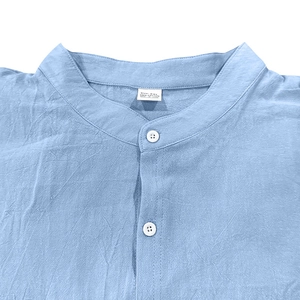Dettaglio del colletto della camicia in cotone azzurro con taglia XXL e etichetta 100% cotone