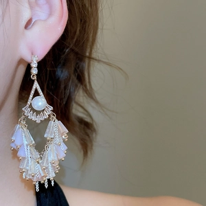 Detail of elegant chandelier earrings with white pearls and purple crystal tassels