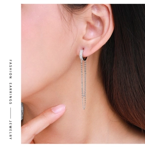 Détail de boucles d'oreilles longues à pampilles en argent avec micro-strass sur modèle