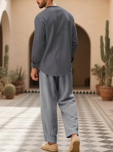 Men's casual loose grey cotton linen set showing back view in a Mediterranean garden