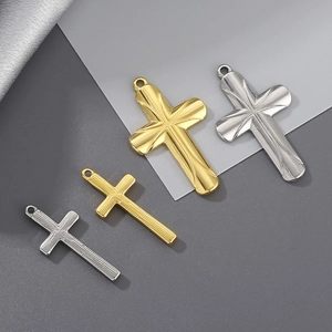 Detailed macro view of gold and silver stainless steel cross pendants in two sizes