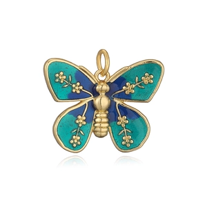 Macro detail of a butterfly pendant with blue and green enamel and golden flower patterns