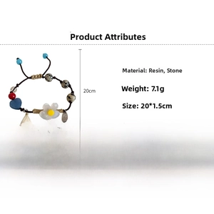 Détail du cœur en résine bleue, perles en pierre et fleur sur le bracelet fait main