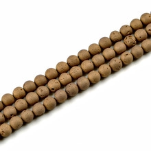 Detailed view of three brown porous terahertz stone bead strands on white background
