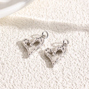 Macro view of silver hollow heart pendants with 18k plated lava texture for DIY jewelry