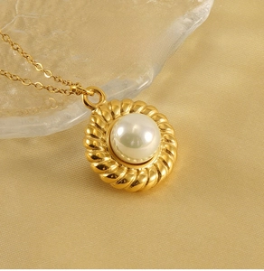 Detailed close-up of 18k gold-plated twisted rope frame pendant with white pearl